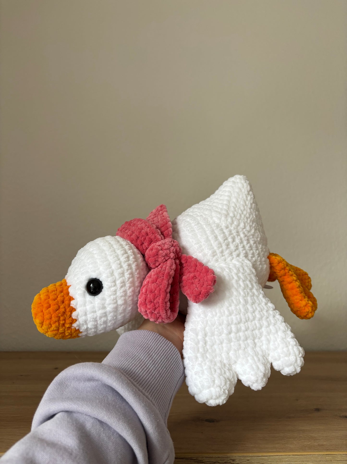 Liegende Gans mit Schleife